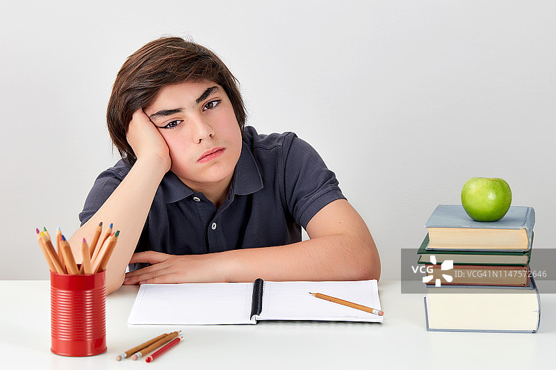 不开心的沮丧白人学生在做作业时感到困惑和愤怒图片素材