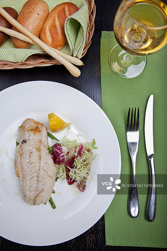 盘中配有蔬菜、柠檬和芦笋的鱼片图片素材