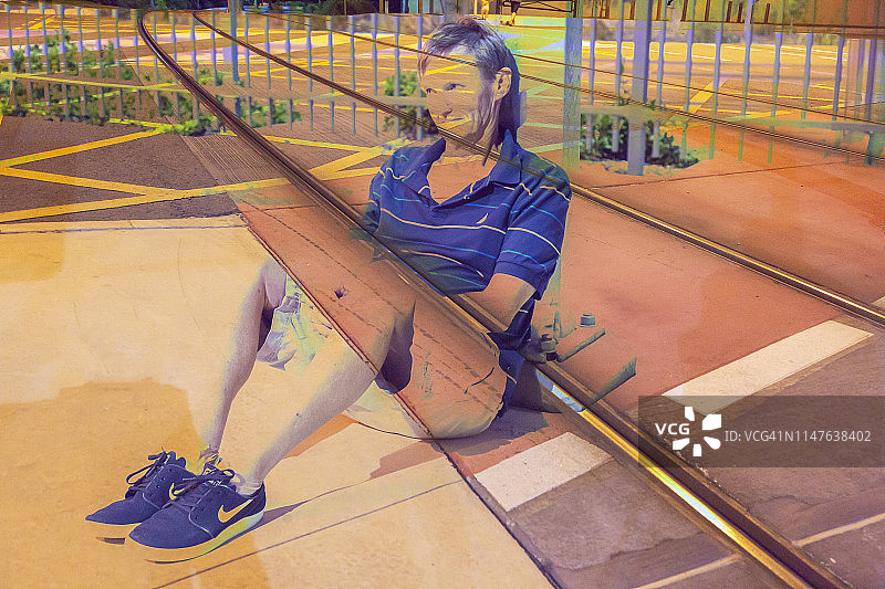 一位老人靠在铁路轨道柱子上的多次曝光图片素材