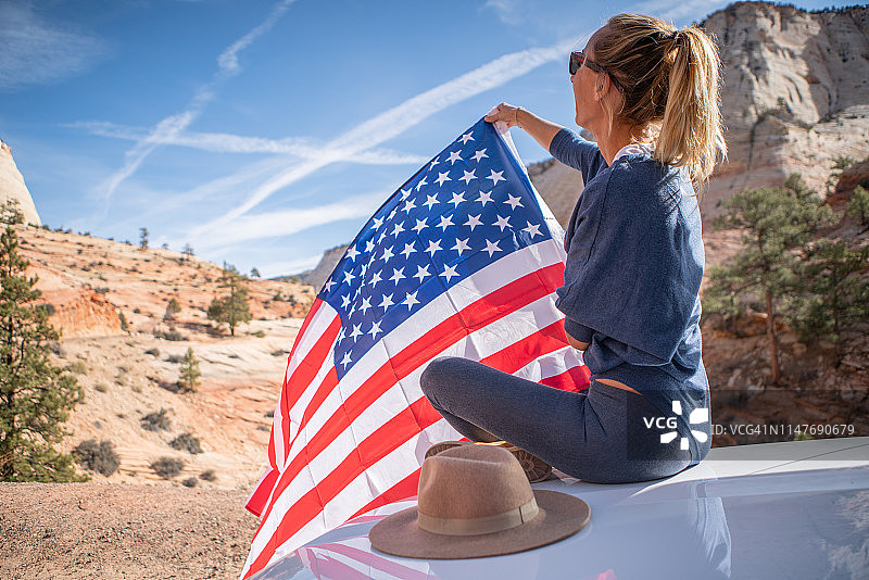 女孩在美国旅行，手持美国国旗图片素材