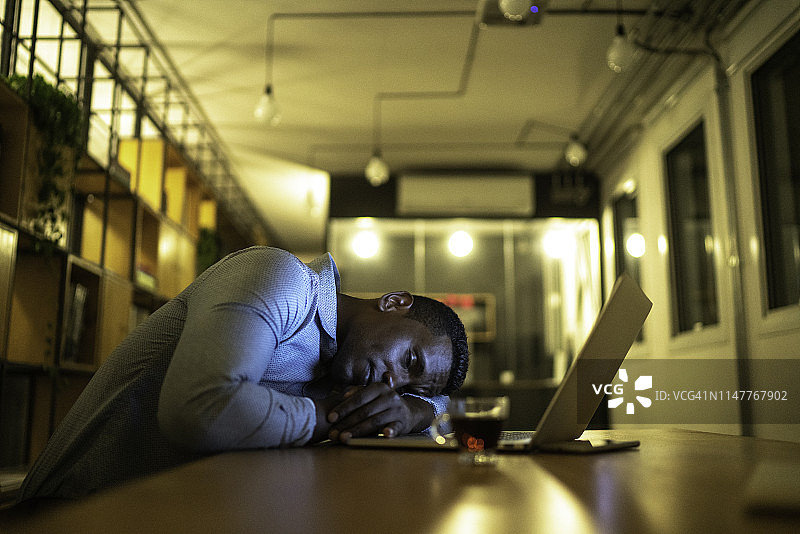 办公桌旁休息的疲惫商人图片素材