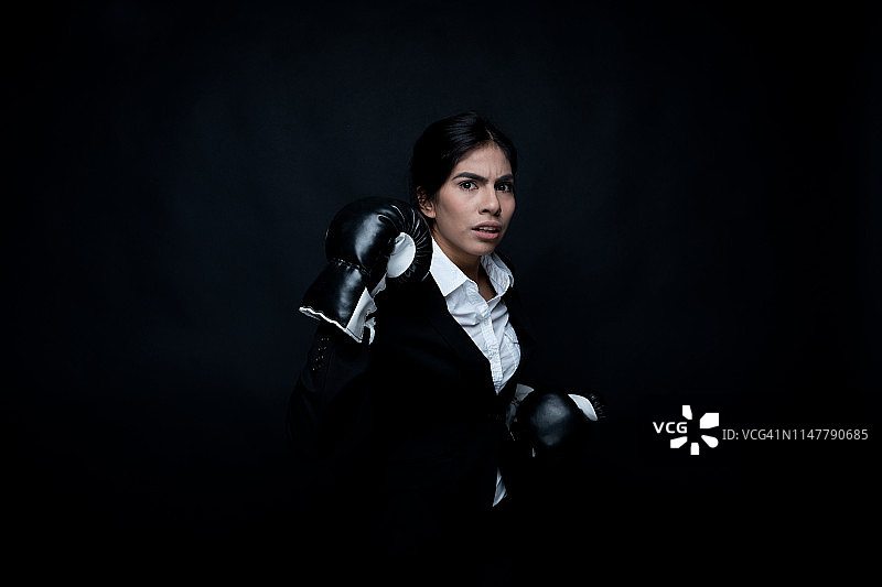 戴着拳击手套的拉丁裔女商人图片素材