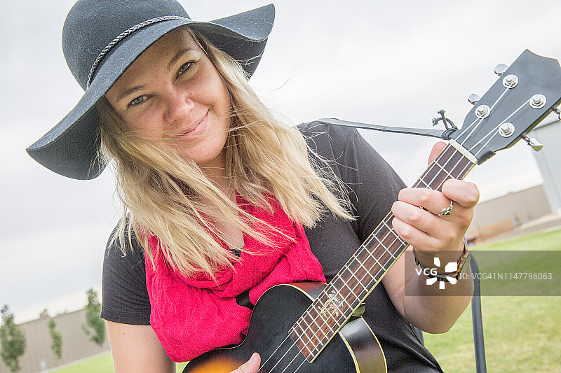 弹尤克里里和班卓琴的年轻女人图片素材
