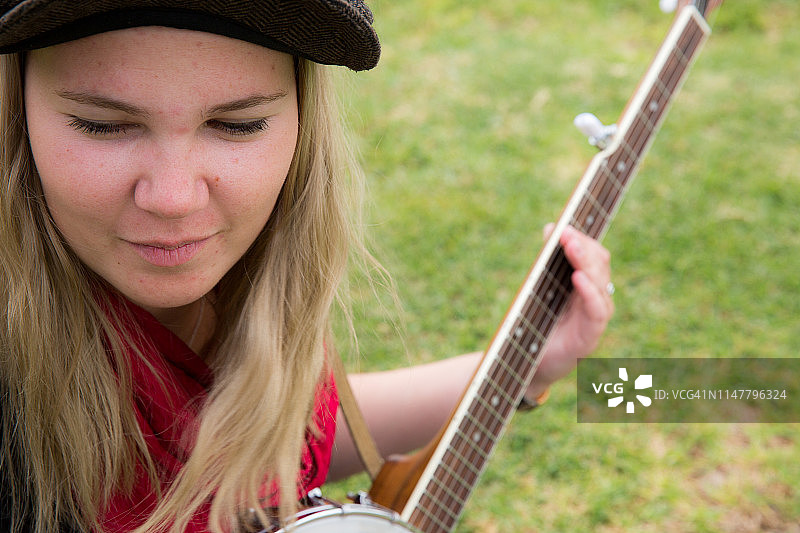 弹尤克里里和班卓琴的年轻女人图片素材