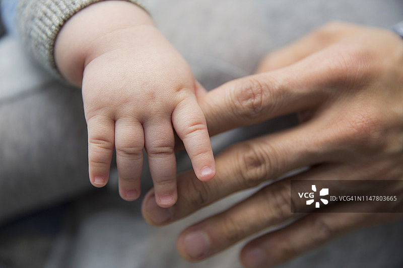 父亲与5个月大混血儿子指尖触碰的温馨瞬间图片素材