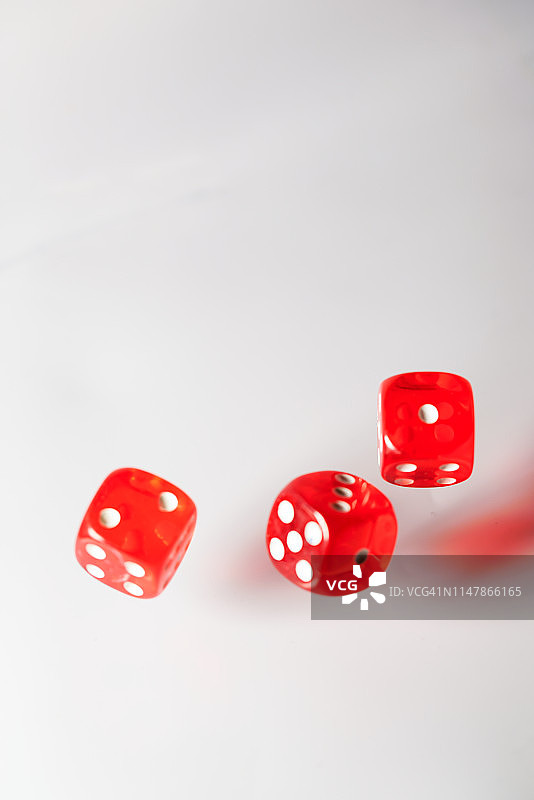 红色骰子在白色背景上飞舞图片素材