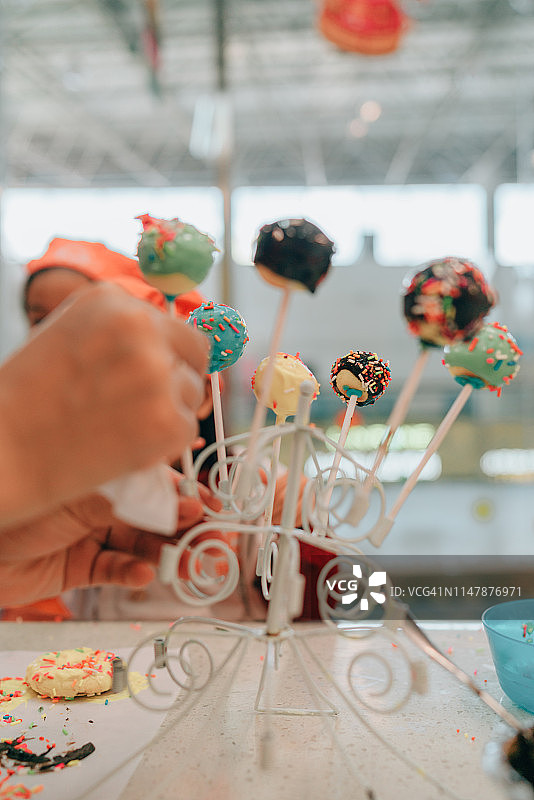 两个亚洲孩子DIY棒棒糖蛋糕图片素材
