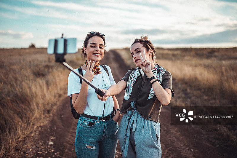快乐的朋友们用自拍杆记录冒险图片素材