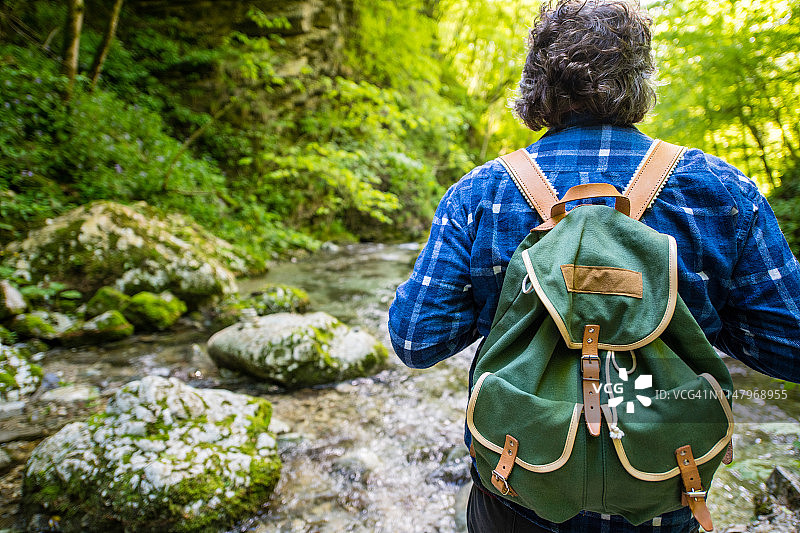 老年男人欣赏斯洛文尼亚科巴里附近朱利安阿尔卑斯山中令人惊叹的科兹亚克峡谷小路图片素材