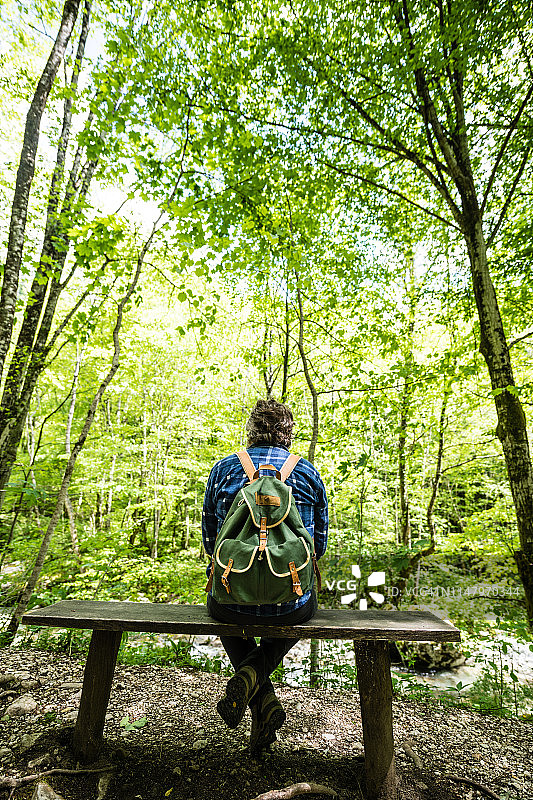 背包男士坐在斯洛文尼亚朱利安阿尔卑斯山森林的长椅上图片素材