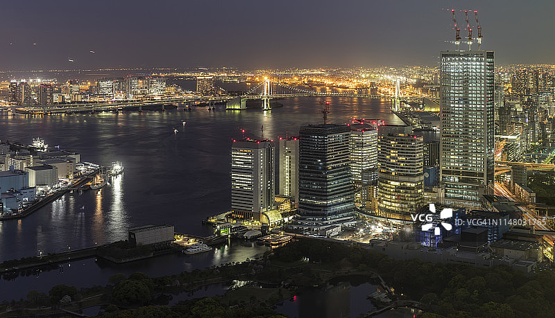 东京御台场彩虹桥与霓虹灯摩天大楼天际线图片素材