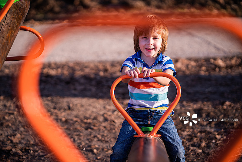 跷跷板上的可爱男孩肖像图片素材
