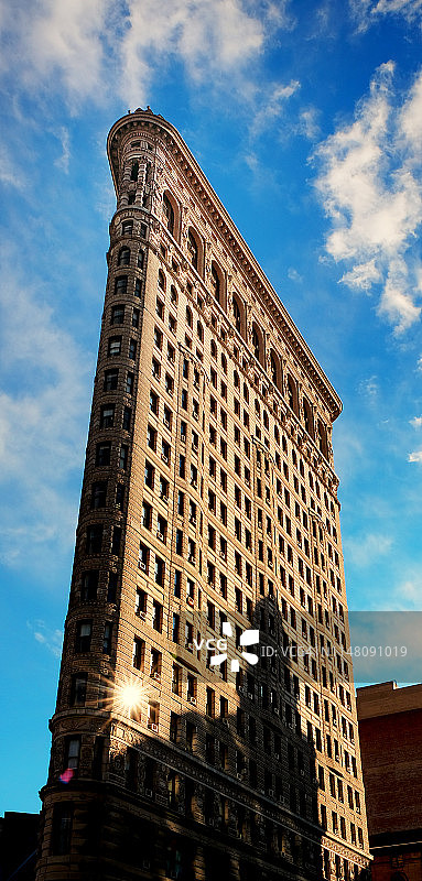曼哈顿熨斗大厦：纽约市最具历史意义和辨识度的建筑之一的立面上的阳光反射图片素材