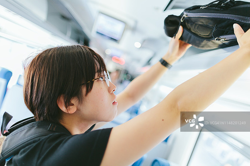 年轻女子独自旅行，将行李放入车内图片素材