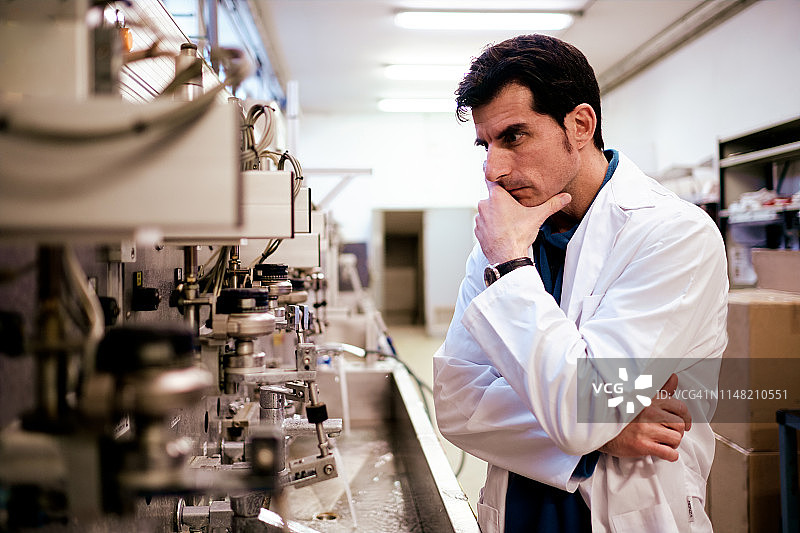 中年男工程师在质量控制实验室检查机器零件图片素材