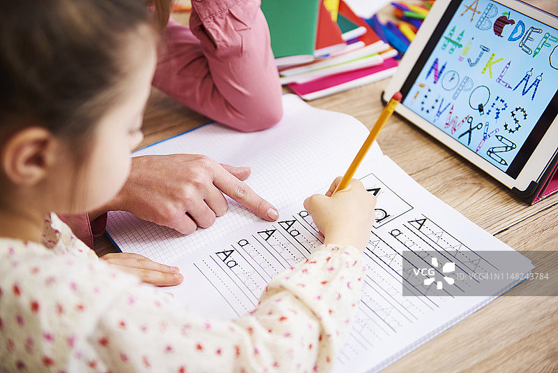 母亲辅导孩子做作业的特写，波兰德比察图片素材