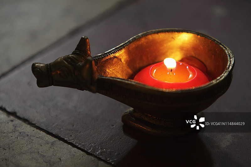 铜牛盘中的点燃蜡烛图片素材