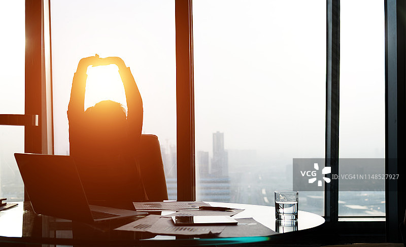 在办公室里向后靠的放松的商务女性图片素材