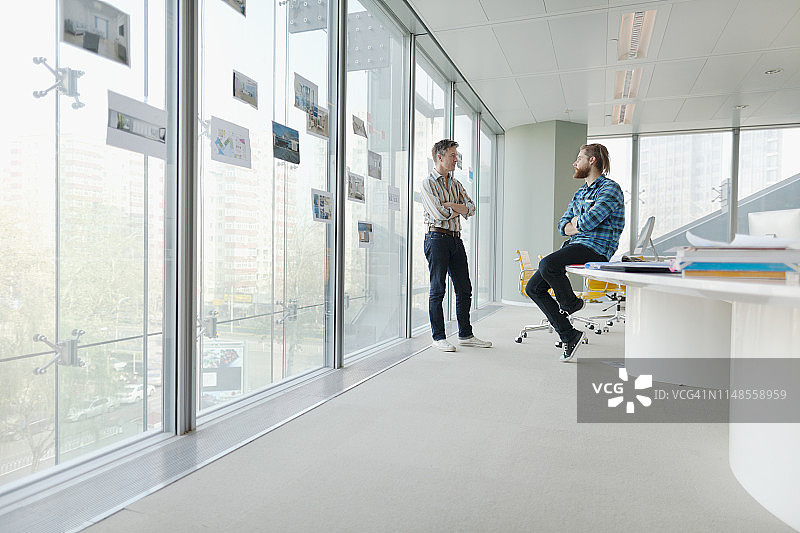 男人们在设计办公室会议室交谈图片素材