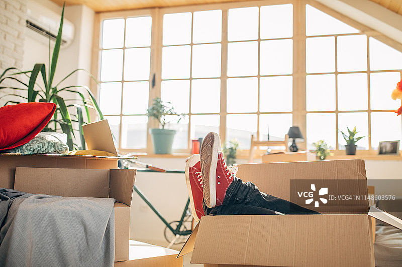 男人坐在搬家纸箱里图片素材