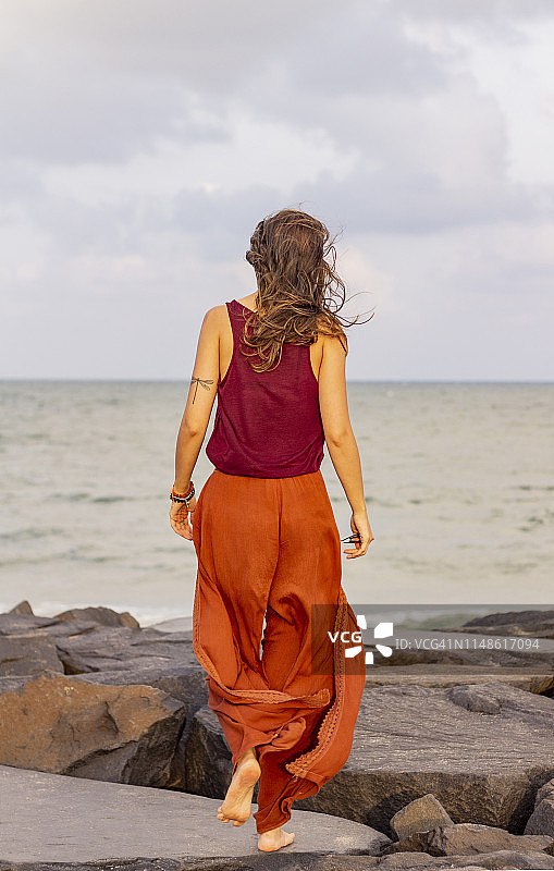 享受海滩的年轻白人女子，背对镜头走开图片素材