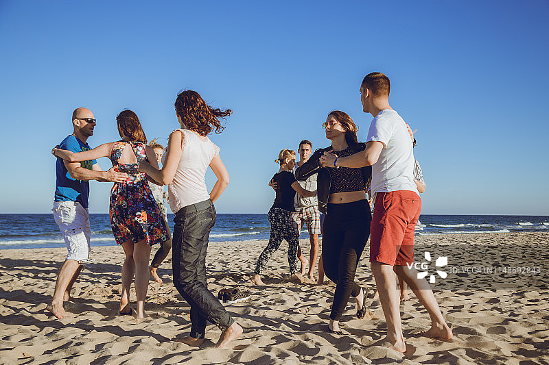 一群朋友在海滩上跳舞图片素材
