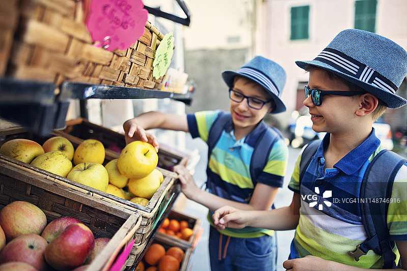 在意大利小镇的蔬菜店购买新鲜苹果的男孩图片素材