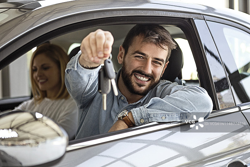 年轻男子手持新车钥匙图片素材