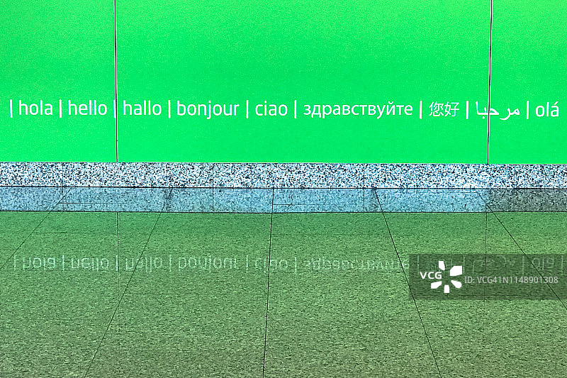 绿色墙壁上用多种语言书写的“你好”图片素材