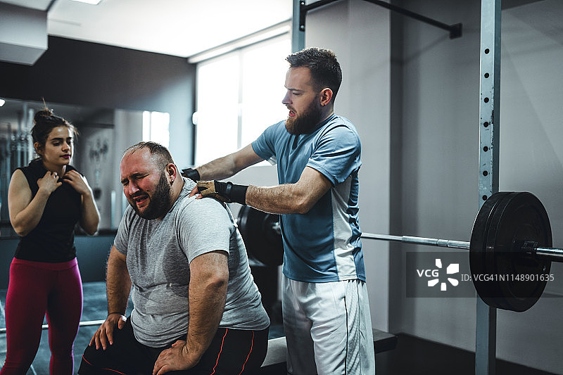 教练鼓励超重中年男子努力训练图片素材