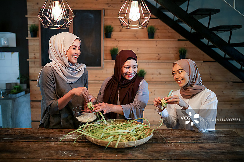 母亲和两个女儿在厨房准备食物图片素材