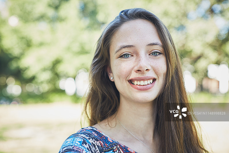 在公园里微笑的年轻女性肖像图片素材