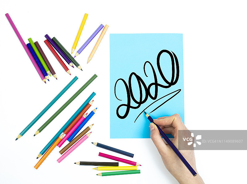 在蓝色纸上用铅笔手写2020图片素材