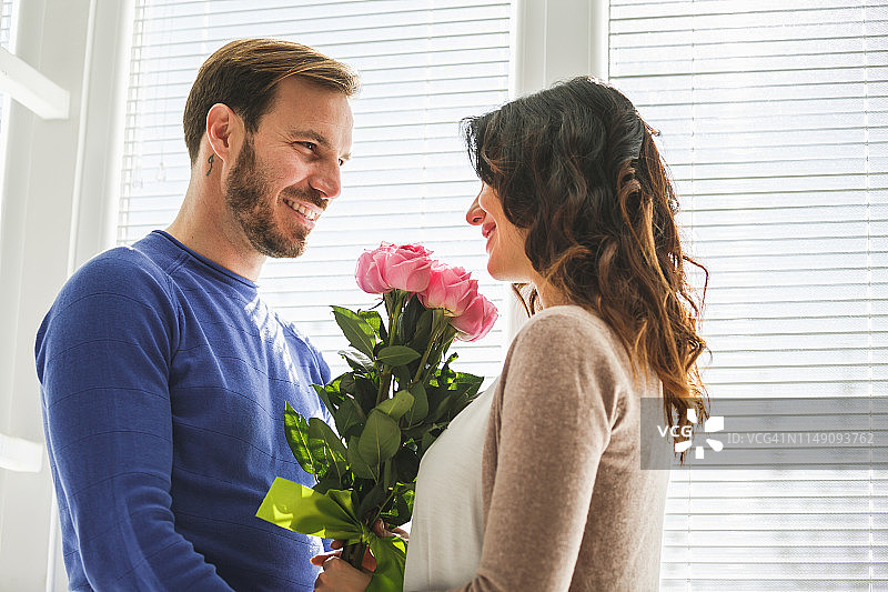 笑容满面的男人和拿着玫瑰的女人图片素材