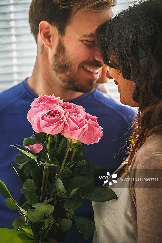 拿着玫瑰花的微笑夫妇图片素材
