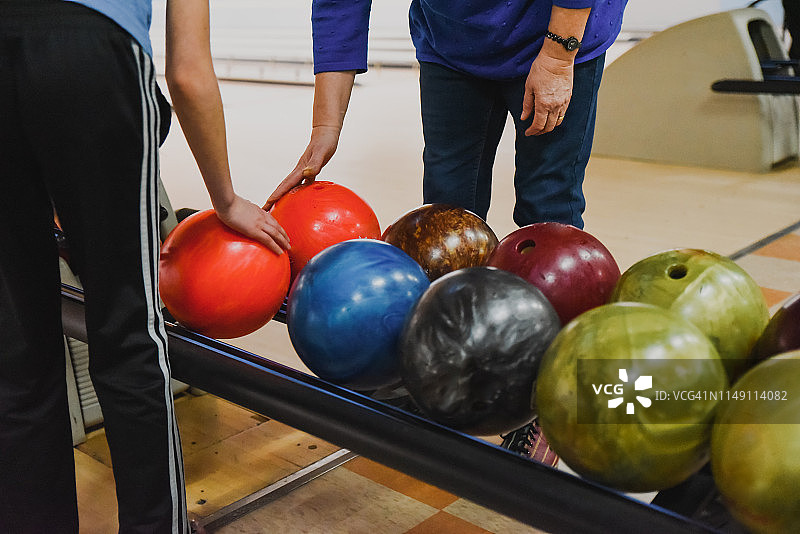 老年妇女和儿童选择保龄球的局部照片图片素材