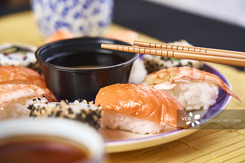 各种寿司，搭配芥末、生姜和深色碗装酱油图片素材