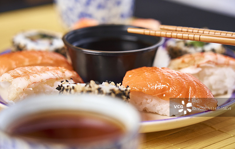 各种寿司，搭配芥末、生姜和深色碗装酱油图片素材