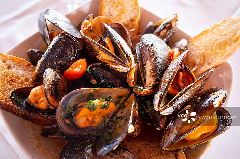 搭配肉汤和吐司的贻贝图片素材