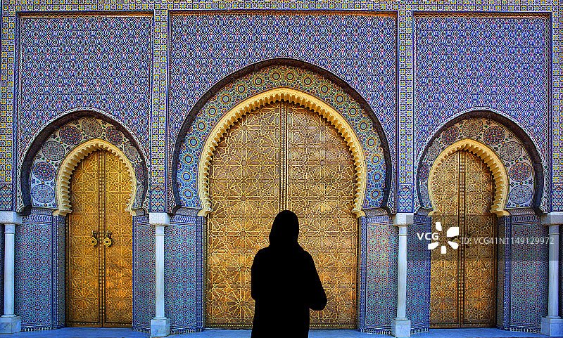 女子站在黄铜门前图片素材