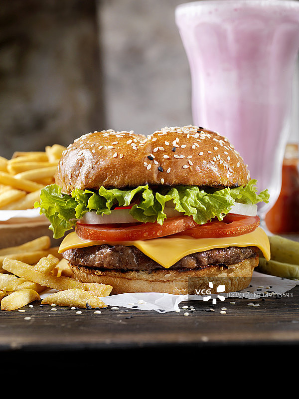 经典芝士汉堡配布里欧面包、薯条和奶昔图片素材