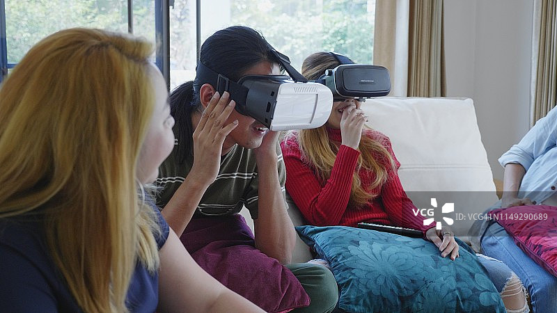 年轻的千禧一代在公寓的客厅里一起玩VR图片素材