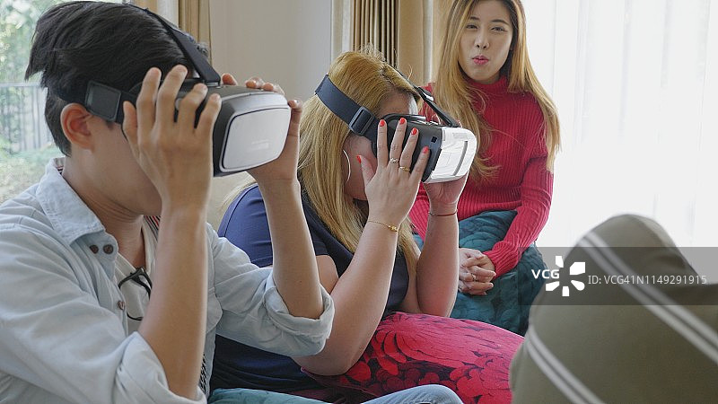 年轻的千禧一代在公寓的客厅里一起玩VR图片素材