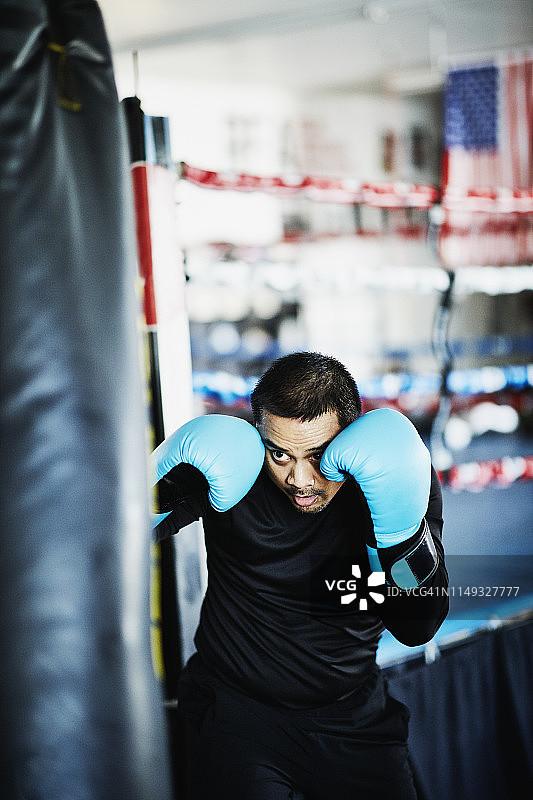 男拳击手在拳击馆训练重拳图片素材