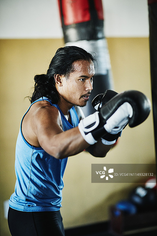 男拳击手在拳击馆训练重拳图片素材