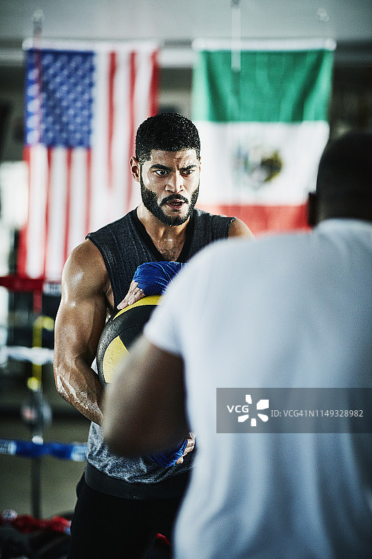男拳击手在拳击房训练时手持药球图片素材