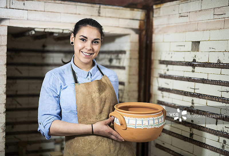 陶瓷工作室里一位微笑的年轻女人肖像图片素材