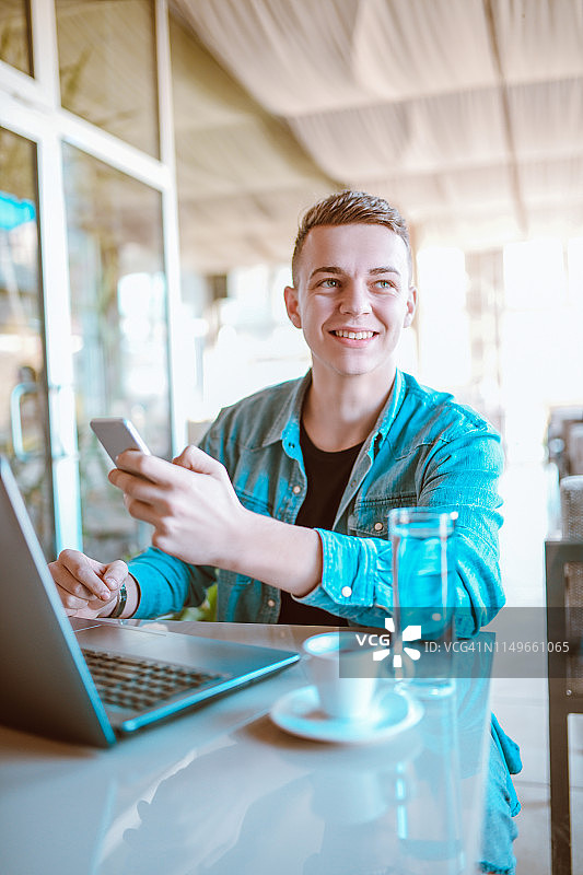 微笑的男人进行手机在线支付图片素材