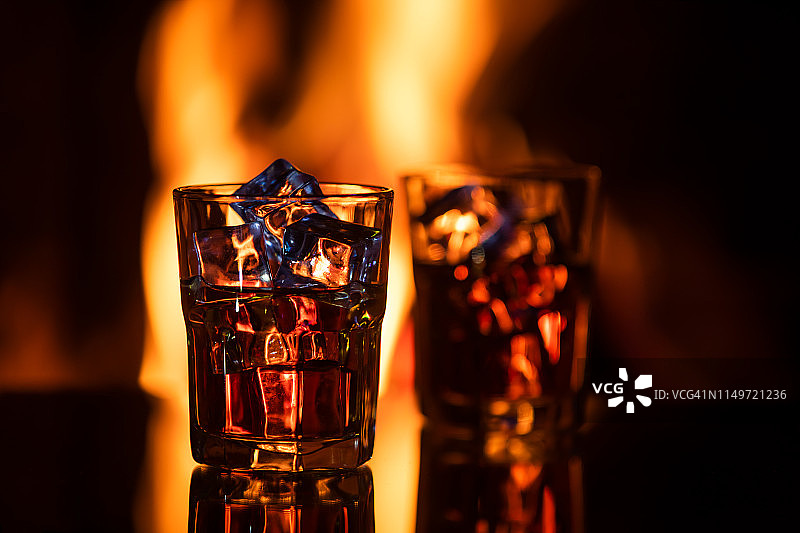 壁炉旁的加冰威士忌酒杯图片素材
