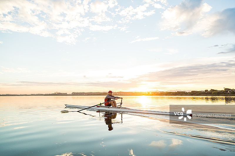 中年男人在黎明时划单人双桨图片素材